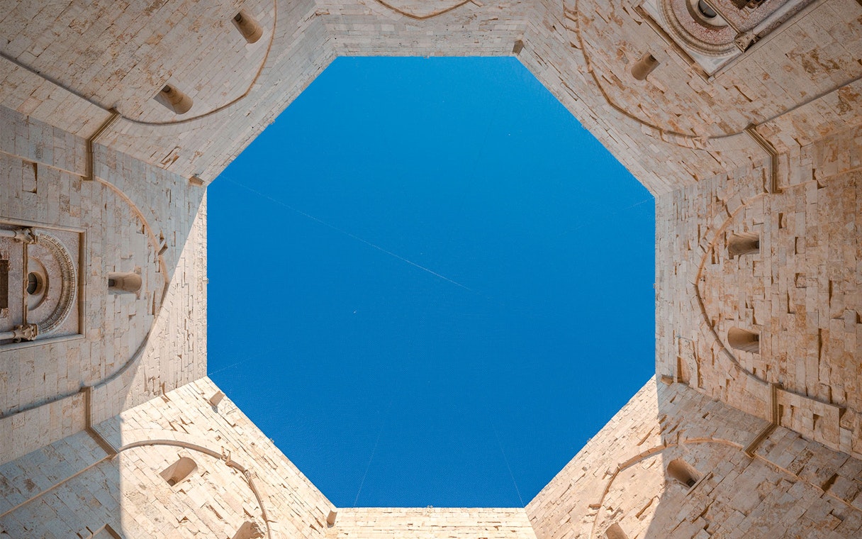 Castel del Monte interior view, octagonal walls under blue sky, Andria, Puglia.