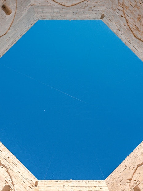 Castel del Monte interior view, octagonal walls under blue sky, Andria, Puglia.
