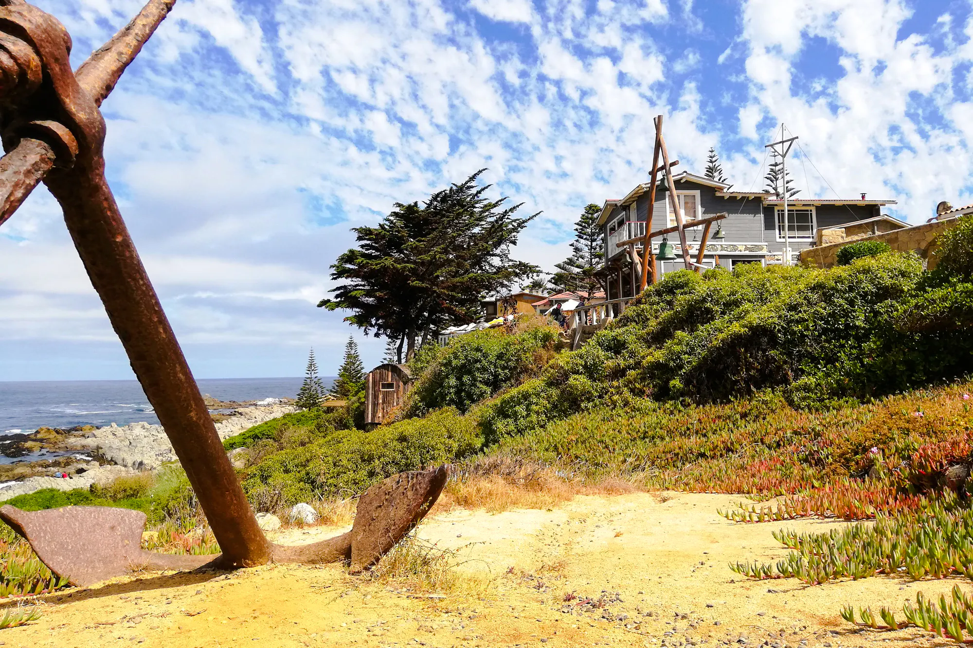 Coastal view of Isla Negra with house and large anchor, part of Santiago day tour.