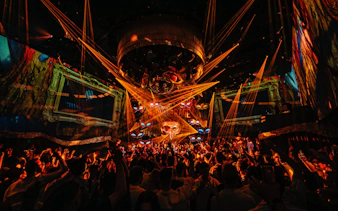 DJ performing at The Masquerade by Claptone, vibrant crowd and lights, Ibiza nightclub.