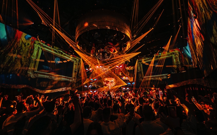 DJ performing at The Masquerade by Claptone, vibrant crowd and lights, Ibiza nightclub.