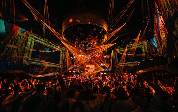 DJ performing at The Masquerade by Claptone, vibrant crowd and lights, Ibiza nightclub.