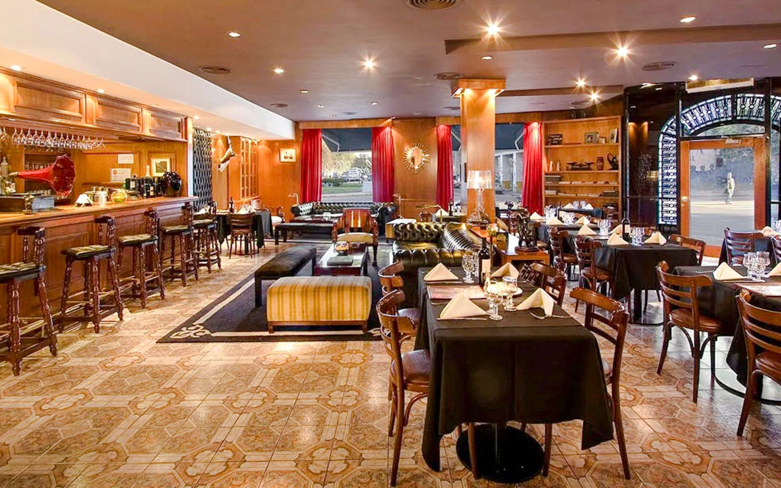 Dining area at El Viejo Almacén with tables set and a bar in Buenos Aires.