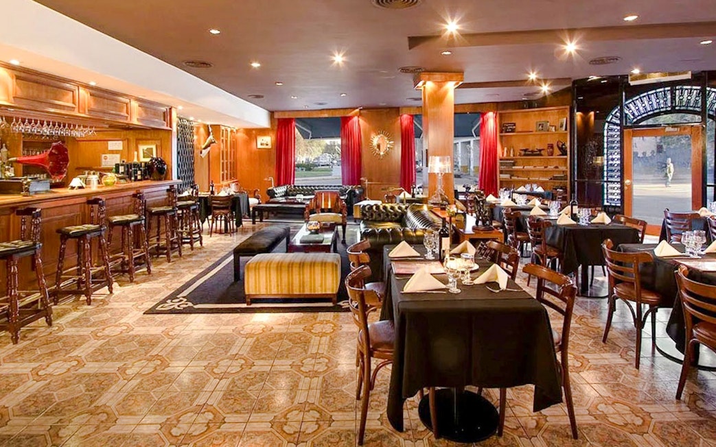 Dining area at El Viejo Almacén with tables set and a bar in Buenos Aires.