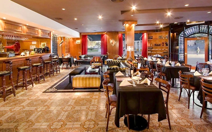 Dining area at El Viejo Almacén with tables set and a bar in Buenos Aires.
