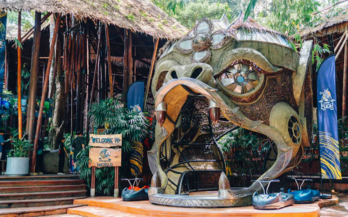 Hanuman World entrance with decorative sculpture and zipline carts in Phuket, Thailand.