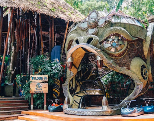 Hanuman World entrance with decorative sculpture and zipline carts in Phuket, Thailand.