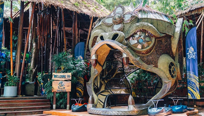 Hanuman World entrance with decorative sculpture and zipline carts in Phuket, Thailand.