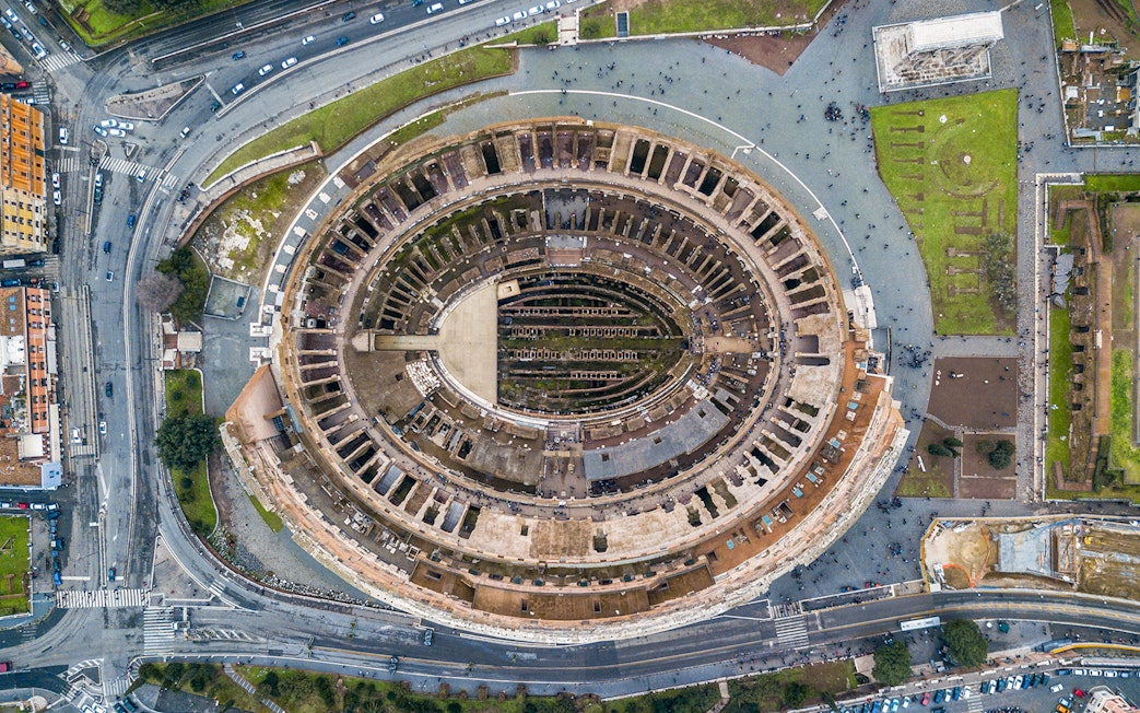 Aerial view of the Colosseum in Rome, Italy, highlighting its ancient architecture.