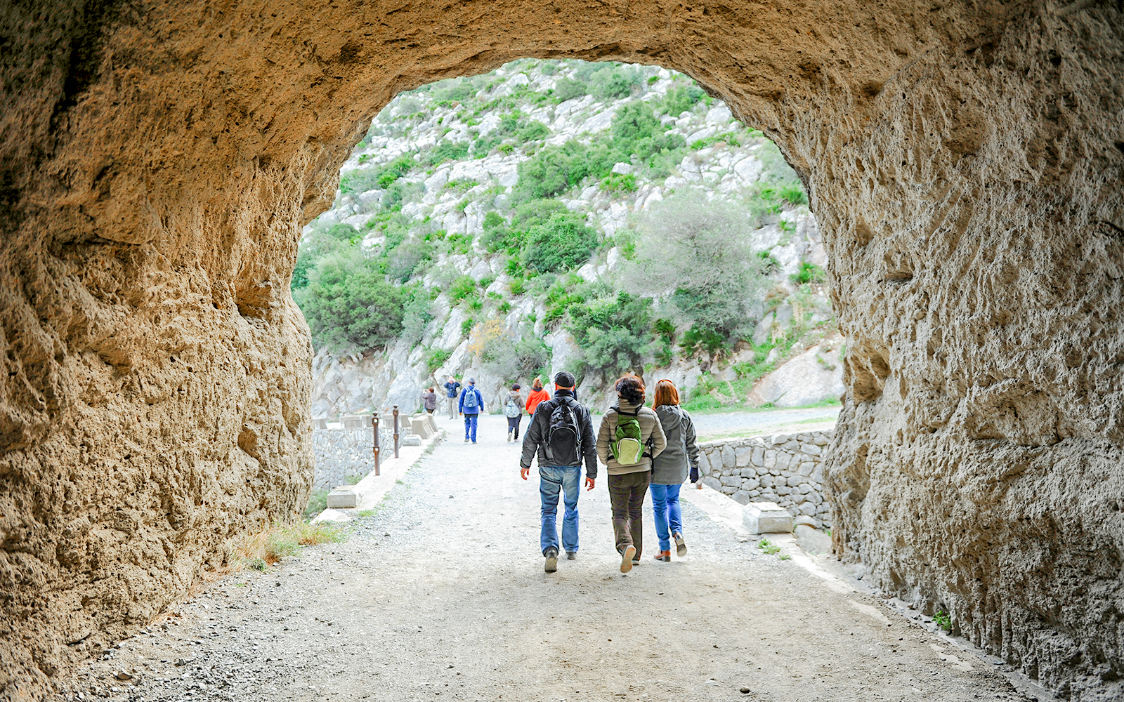 Hikers exiting Tafonis tunnel on Caminito del Rey guided tour in Spain.