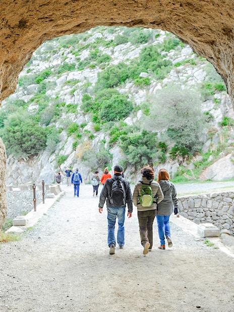 Hikers exiting Tafonis tunnel on Caminito del Rey guided tour in Spain.