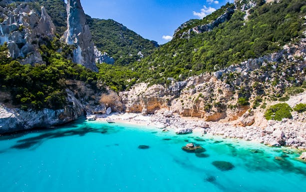 Cala Goloritzè beach with turquoise waters and rocky cliffs, Sardinia trekking tour.