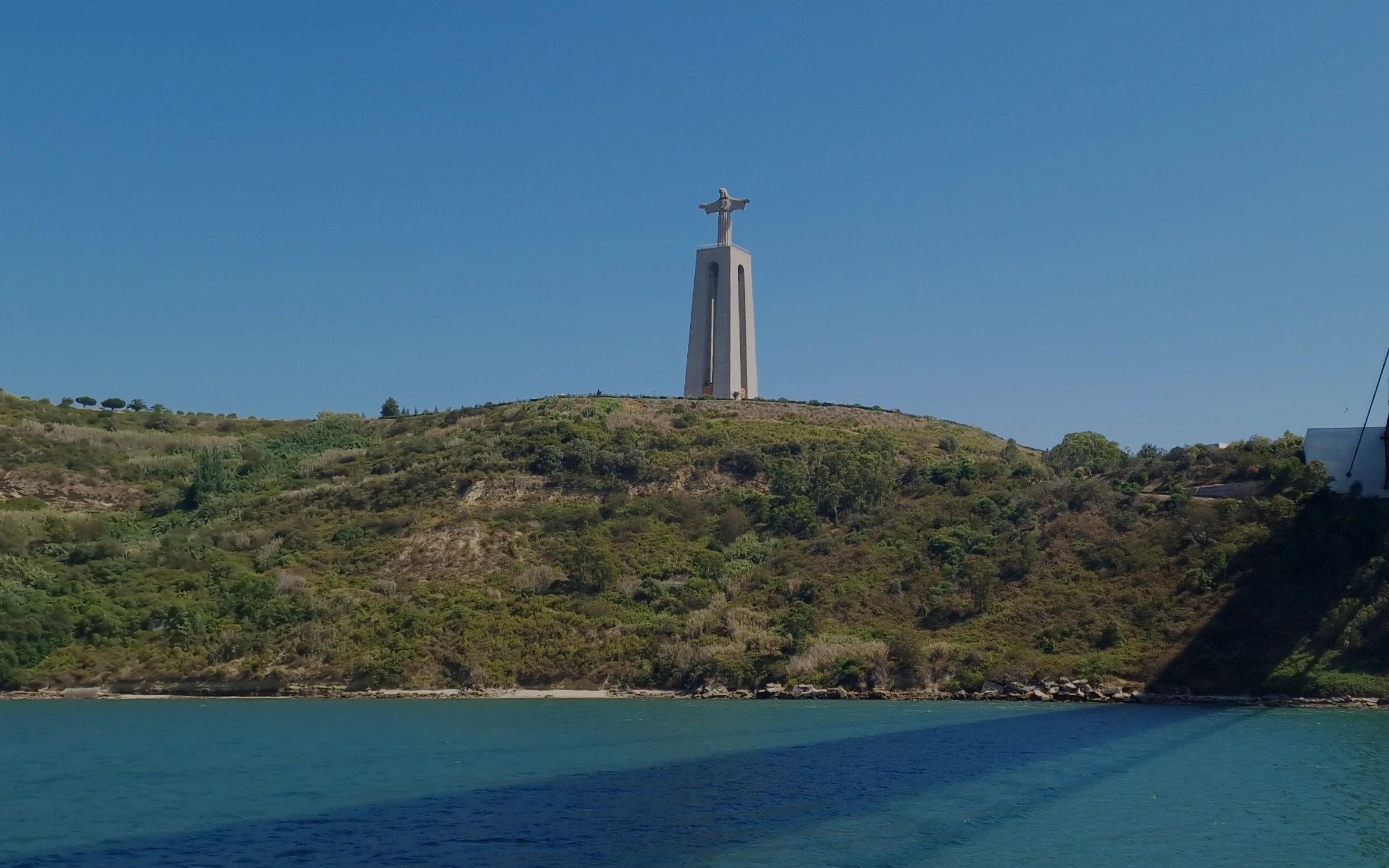 Sanctuary of Christ the King statue on a hill overlooking the Tagus River, Lisbon, Portugal.