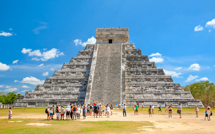 Tourists exploring El Castillo pyramid at Chichen Itza, Yucatán, Mexico.
