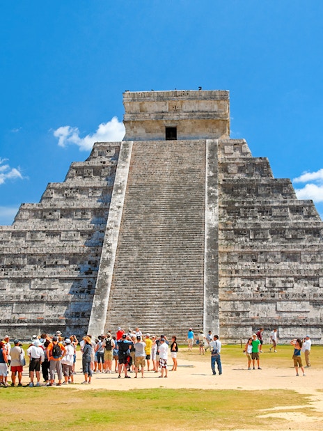 Tourists exploring El Castillo pyramid at Chichen Itza, Yucatán, Mexico.
