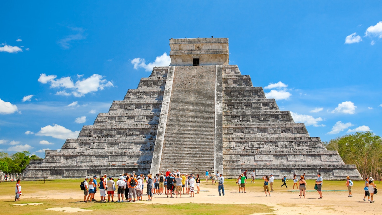 Tourists exploring El Castillo pyramid at Chichen Itza, Yucatán, Mexico.
