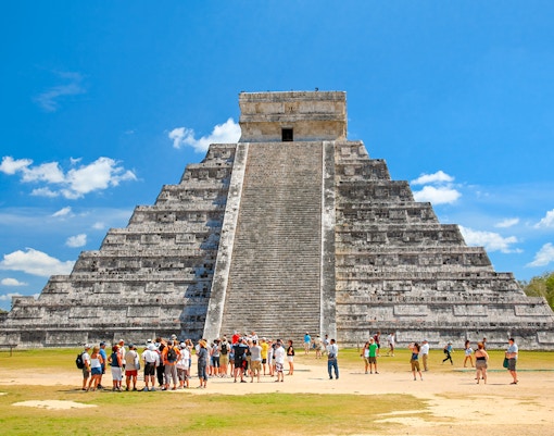 Tourists exploring El Castillo pyramid at Chichen Itza, Yucatán, Mexico.