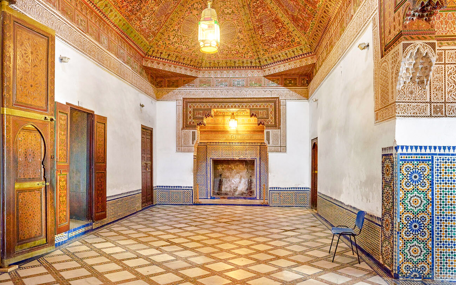 Ornate interior of Bahia Palace in Marrakech, Morocco, featuring intricate tilework and carved wooden doors.