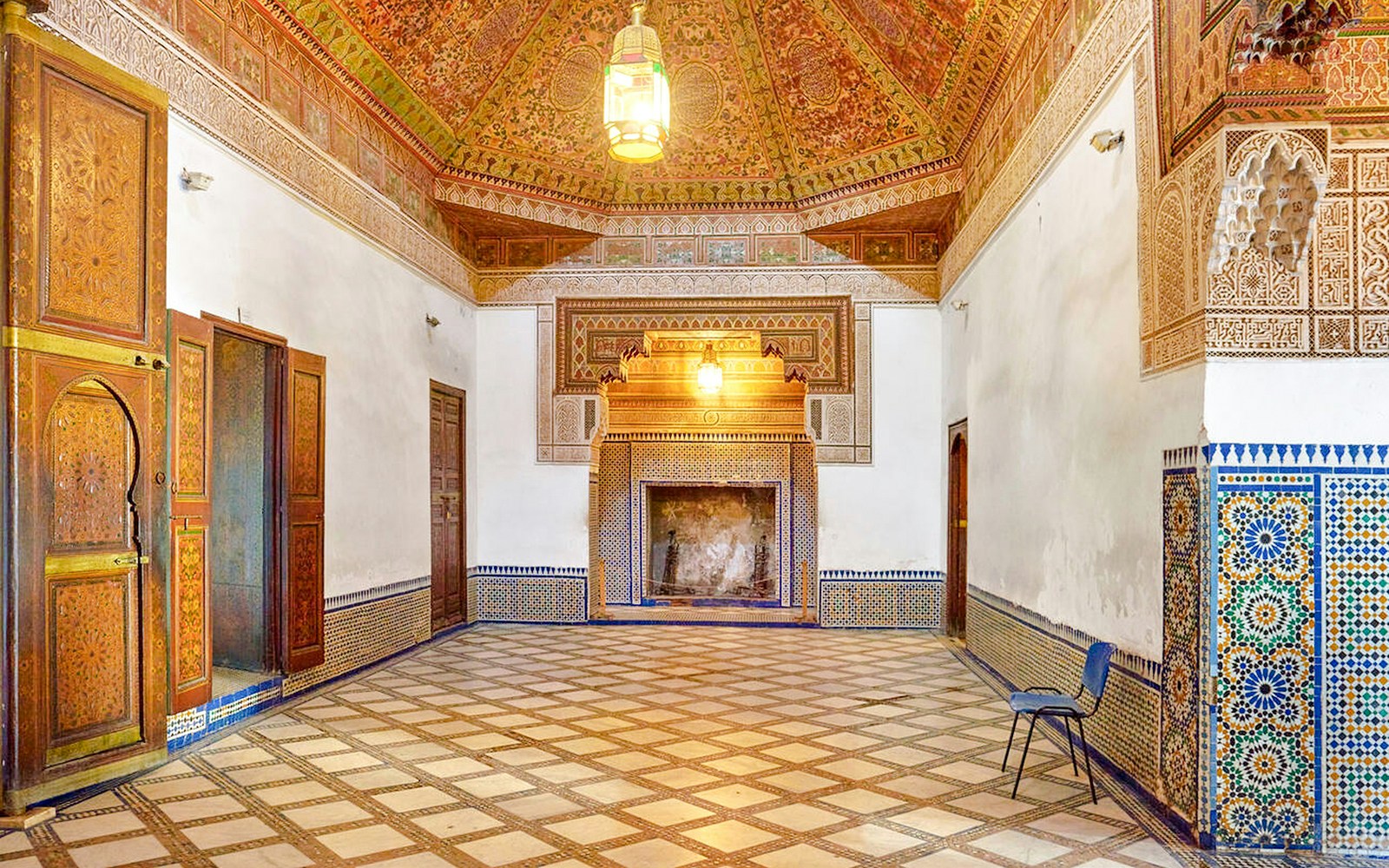 Ornate interior of Bahia Palace in Marrakech, Morocco, featuring intricate tilework and carved wooden doors.