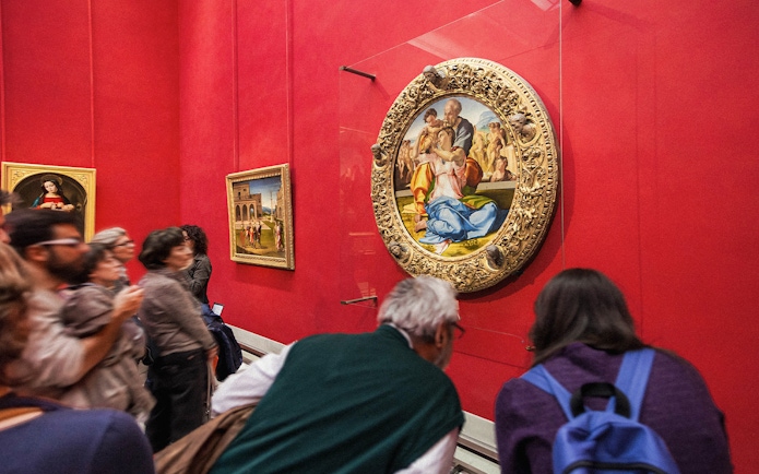 Tourists viewing Renaissance paintings at the Uffizi Gallery, Florence, Italy.