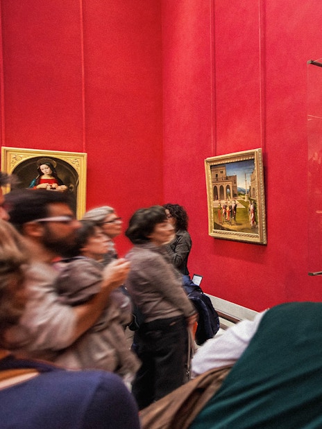 Tourists viewing Renaissance paintings at the Uffizi Gallery, Florence, Italy.