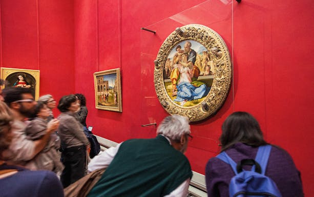Tourists viewing Renaissance paintings at the Uffizi Gallery, Florence, Italy.