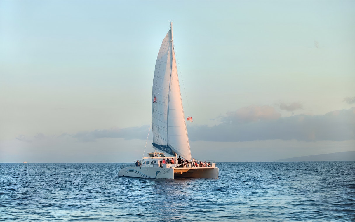 Catamaran sailing at sunset during whale watching tour in Maui, Hawaii.