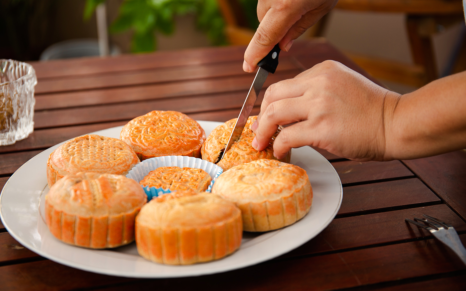 Cutting mooncakes on a plate, showcasing traditional designs.