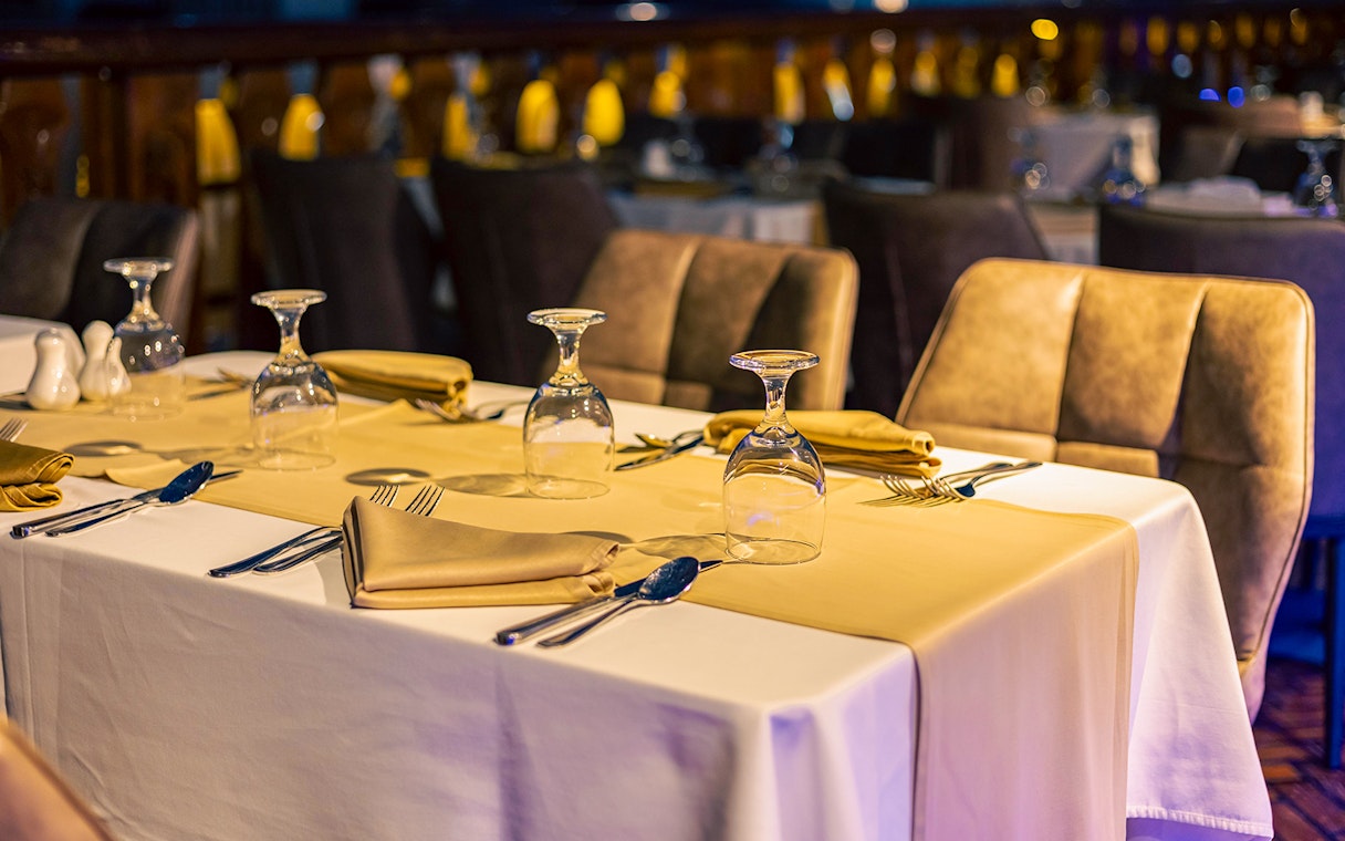 Dinner tables set with glassware and napkins on Alexandra VIP Dhow Cruise.