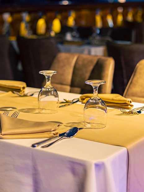 Dinner tables set with glassware and napkins on Alexandra VIP Dhow Cruise.