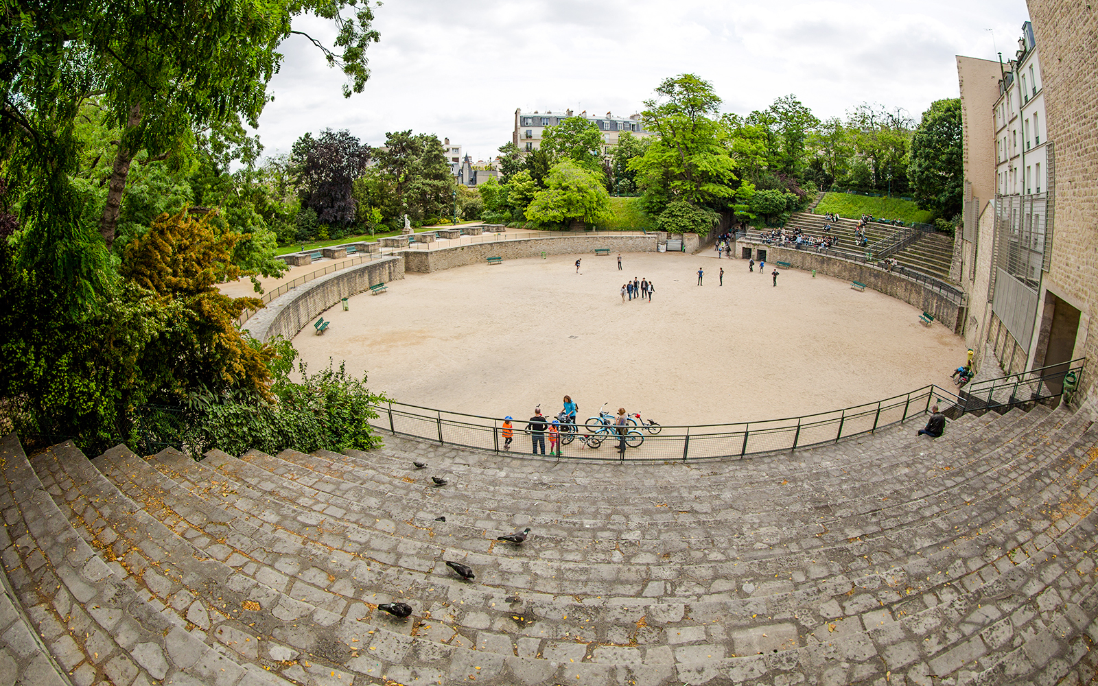 Arenes de Lutece amphitheater in Paris, France, with visitors exploring the historic site.