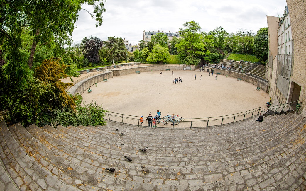 Arenes de Lutece amphitheater in Paris, France, with visitors exploring the historic site.