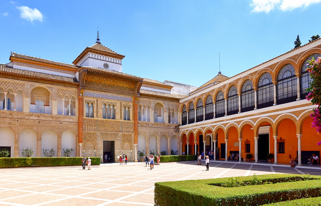 Innenhof des Alcázar von Sevilla in Spanien bei blauem Himmel