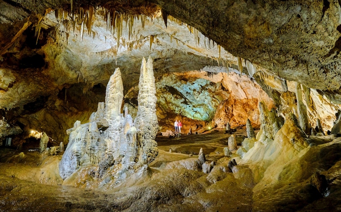 Tourists exploring stalagmites and stalactites inside Lipa Cave, Cetinje.