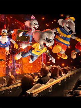 Animated characters flying over an audience in a 4D Adventureland theater experience.