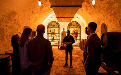Tour group inside Carlsberg cellar with stained glass and statue exhibit.