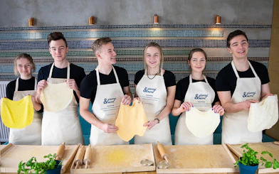 Participants holding dough at a Polish dumplings cooking class.