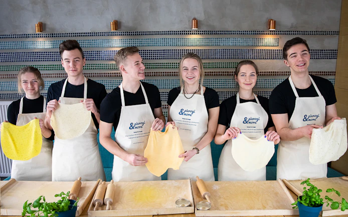 Participants holding dough at a Polish dumplings cooking class.