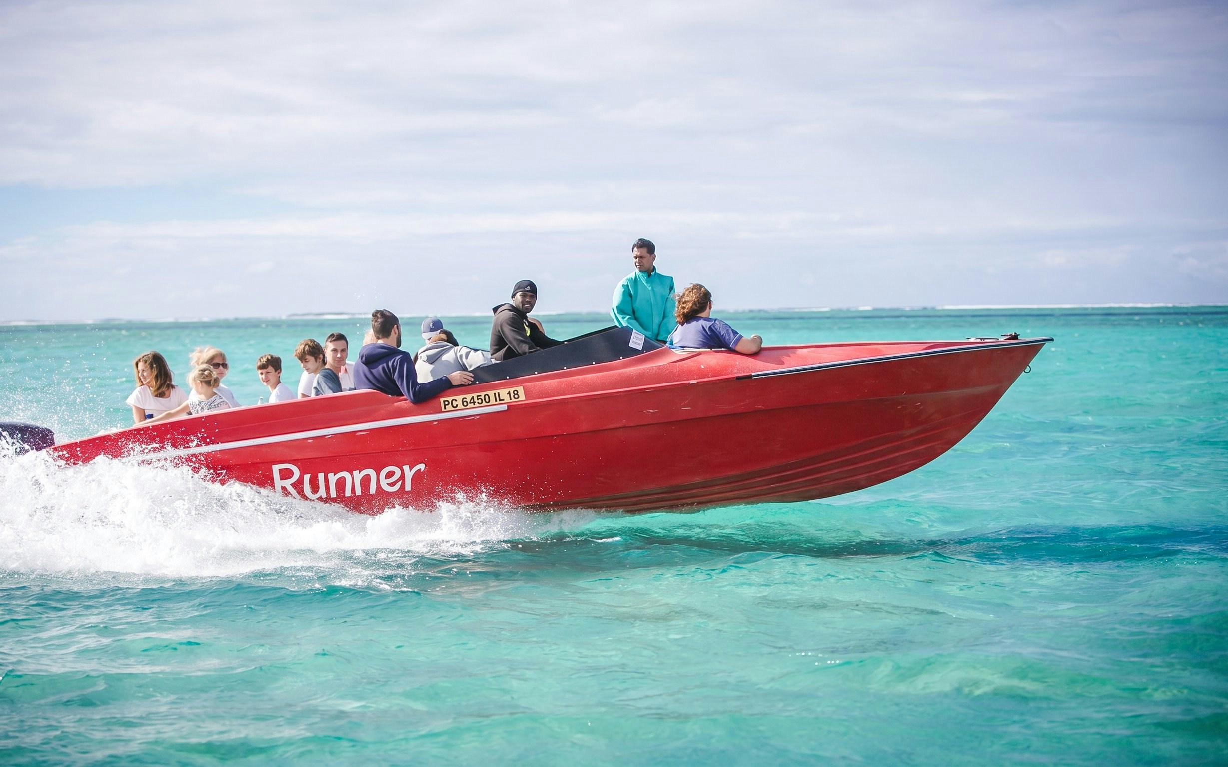 Speedboat with passengers on turquoise waters near Ile Aux Cerf.