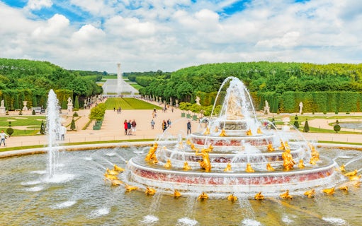 Latona Fountain Pool at Palace of Versailles with gardens and visitors.