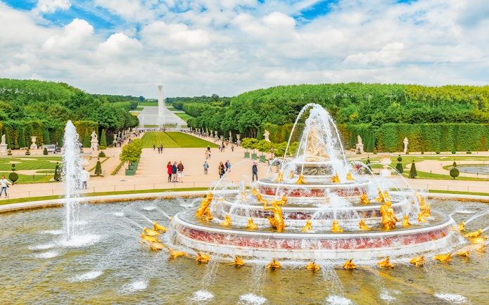 Latona Fountain Pool at Palace of Versailles with gardens and visitors.