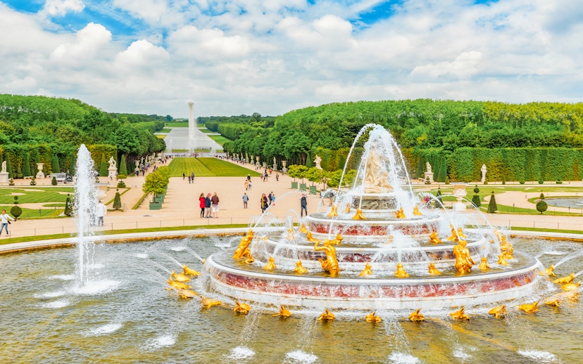 Latona Fountain Pool at Palace of Versailles with gardens and visitors.