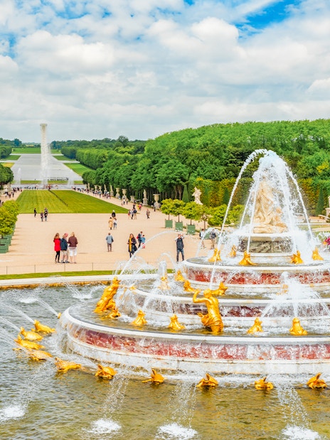 Latona Fountain Pool at Palace of Versailles with gardens and visitors.