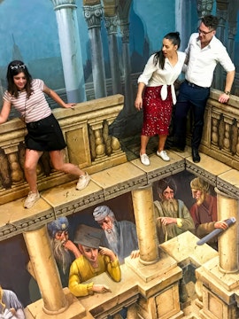 Visitors interacting with 3D illusion art at ArtVo Trick-Art Gallery.