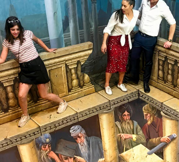 Visitors interacting with 3D illusion art at ArtVo Trick-Art Gallery.