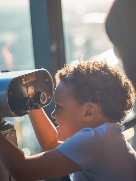 Child using a telescope at Melbourne Skydeck, Eureka Tower.