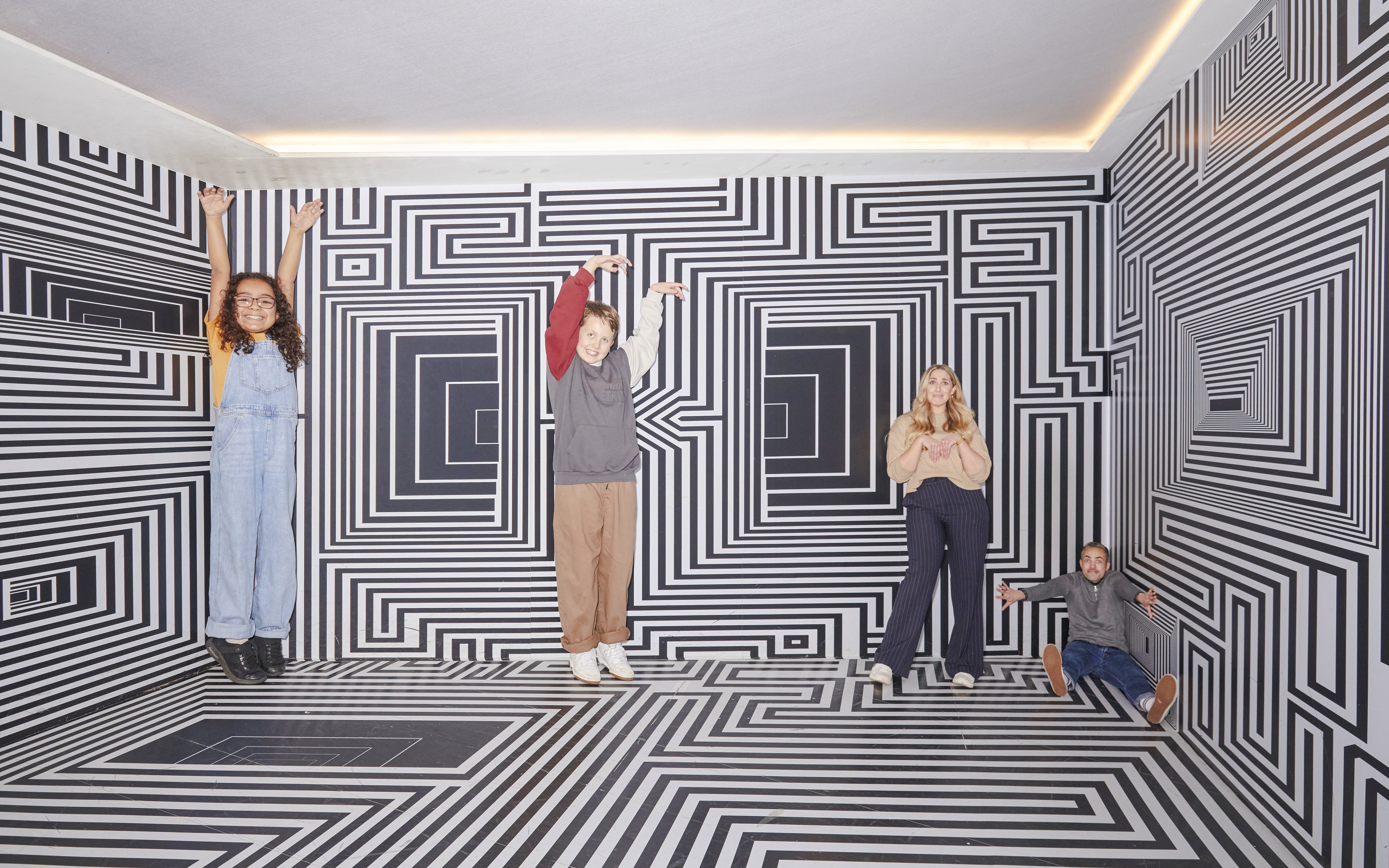 Guests interacting with optical illusions at the Twist Museum in London.