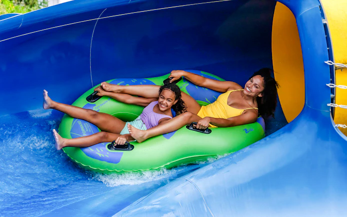 Two people enjoying a water slide ride at Adventure Island, Tampa.