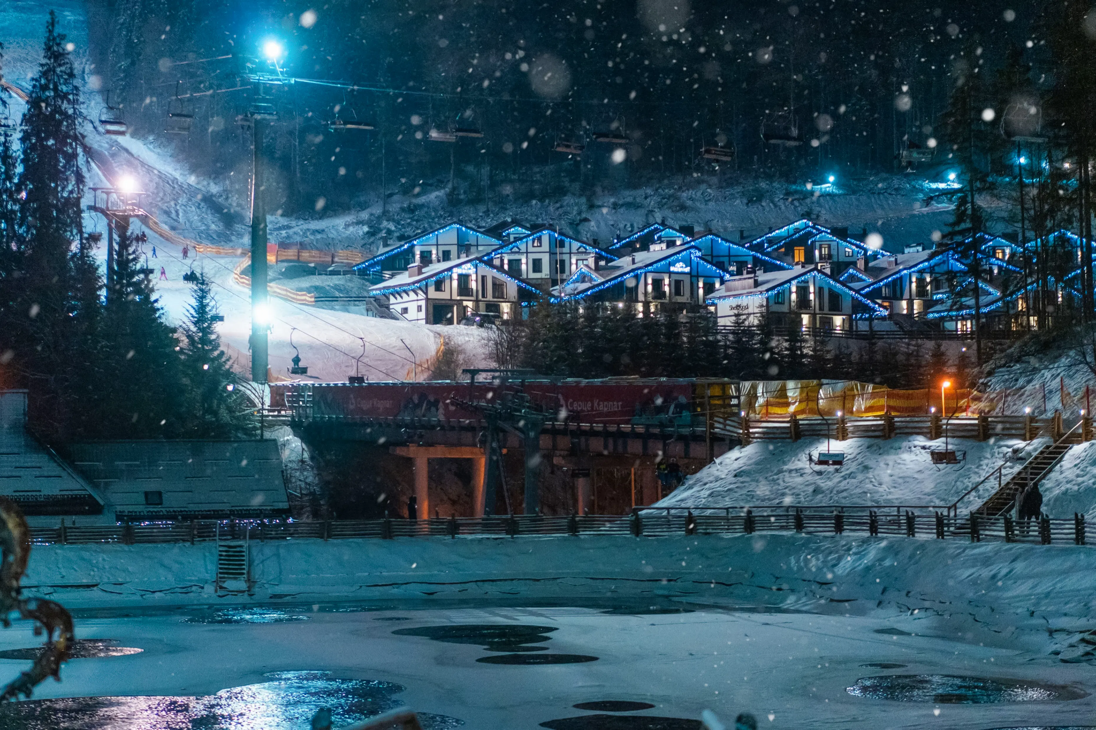 Ski resort in Zakopane with illuminated chalets and snowy slopes at night, Tatra Mountains.