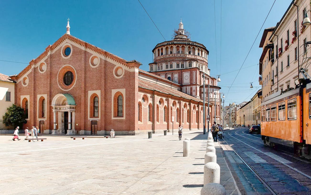 Church of Santa Maria delle Grazie in Milan with tram passing nearby.